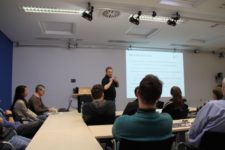 Bild eines Seminarraumes mit Zuhörern und eines Vortragenden