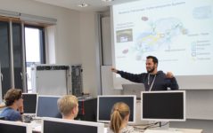 Bild von Stefan Wildermann vor der Leinwand mit einer Vorlesungsfolie im Hintergrund