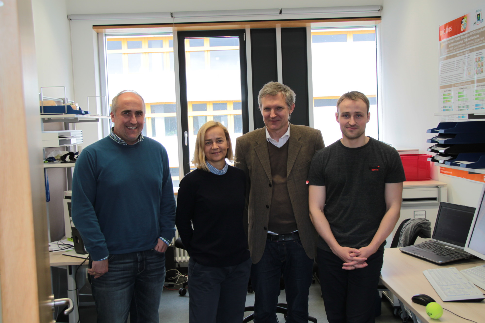 4 Personen stehend in einem Büro; v.l.: Dr. Hannig, Prof. Sciuto, Prof. Teich, S. Roloff