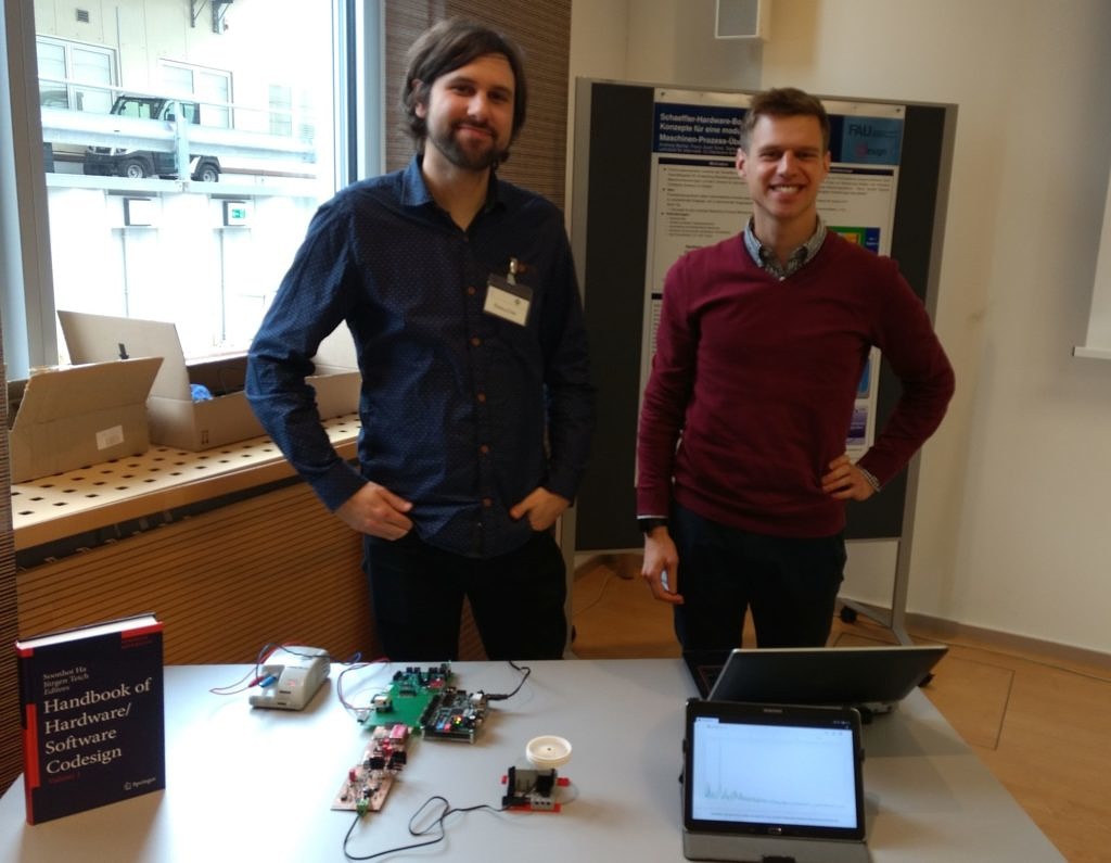 Andreas Becher und Franz-Josef Streit präsentieren die vor Ihnen auf dem Tisch aufgestelle Hardware Box bei Schaeffler