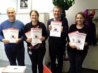 Bild von vier Personen mit einem Antrag in der Hand