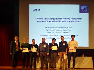 Gruppe von Personen mit Urkunden in der Hand auf einem Podium