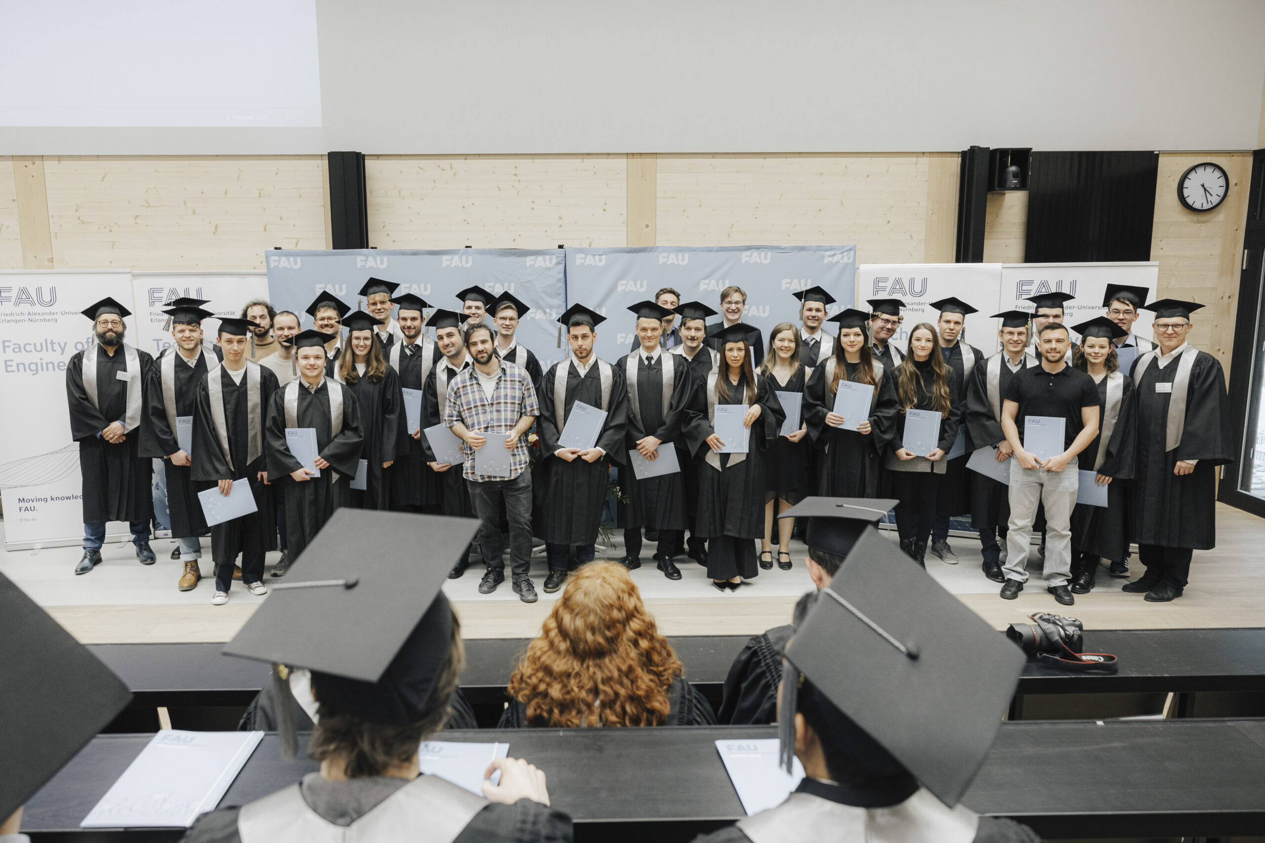 Eine Gruppe von Personen auf einer Bühne mit Talaren